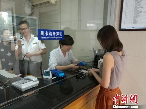 中國僑網(wǎng)圖為:出國人員體檢現(xiàn)場?!∮莠摤摗z