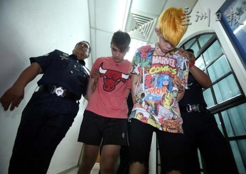 中國僑網(wǎng)染著金發(fā)的19歲被告梁忠興,,與20歲的馮凌舟,低著頭被押致法庭面控,人名皆譯音,。(馬來西亞《星洲日報》)