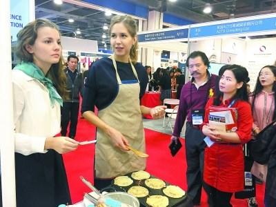 中國僑網(wǎng)俄羅斯展區(qū)的美少女化身小廚娘,現(xiàn)場攤起了俄羅斯薄餅,。