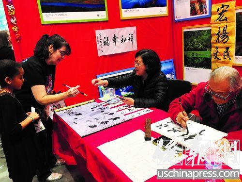中國僑網(wǎng)呂梧鳴老人(右)展示書法。(美國《僑報》/毛萇子 攝)