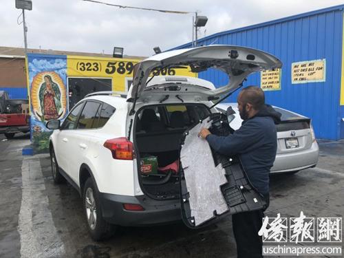 中國僑網(wǎng)修車廠工人正在為鄧女士豐田車安裝后玻璃,。(美國《僑報》/高睿 攝)
