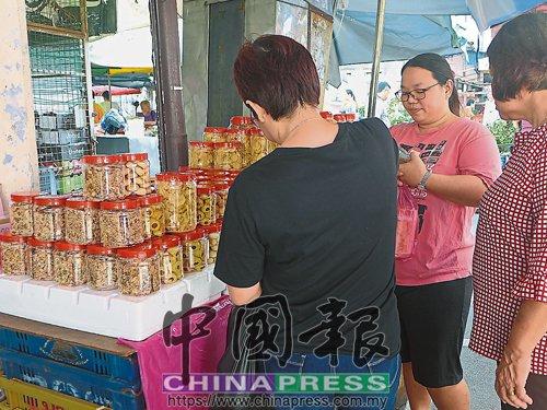 中國僑網(wǎng)吳麗媚(右2)的傳統(tǒng)年餅,,除了有顧客上門選購?fù)猓灿惺炜屯ㄟ^網(wǎng)上WhatsApp訂購,。(馬來西亞《中國報(bào)》)