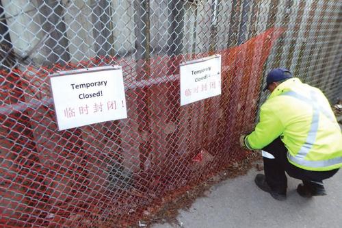 中國僑網(wǎng)市政工人用中英文寫著“Temporary closed,,臨時(shí)封閉”,。(加拿大《星島日?qǐng)?bào)》)