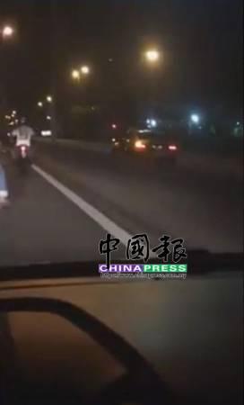 中國僑網(wǎng)失智老翁在北海外環(huán)公路反方向行駛,,一位摩托司機跟隨制止,。(馬來西亞《中國報》圖片)