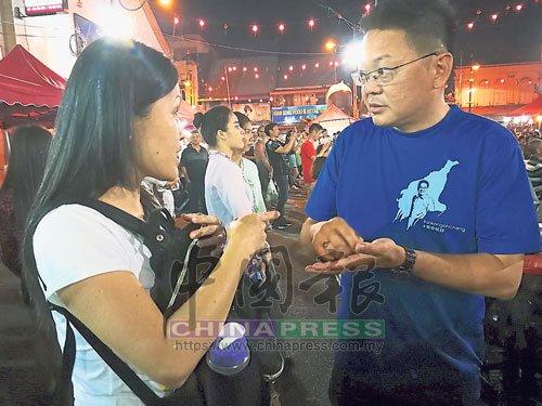中國(guó)僑網(wǎng)杜繩禎(右)在活動(dòng)現(xiàn)場(chǎng)并為市民解答疑問(wèn)。(馬來(lái)西亞《中國(guó)報(bào)》)