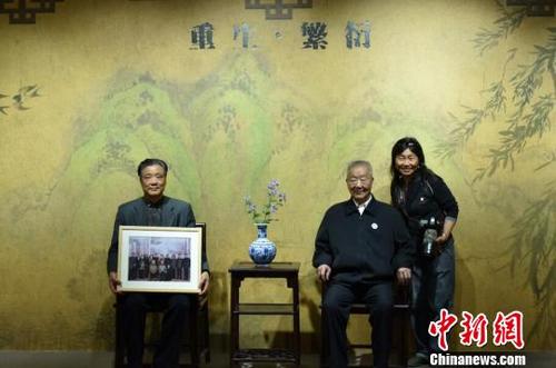 中國僑網(wǎng)南京大屠殺幸存者家屬和攝影師在紀念館內(nèi)攝影留念,。 蔡美婷 攝