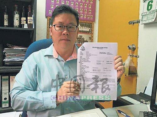 中國僑網(wǎng)都賴州議員鐘紹安手持報案紙,提醒民眾勿上當(dāng)受騙。(馬來西亞《中國報》)