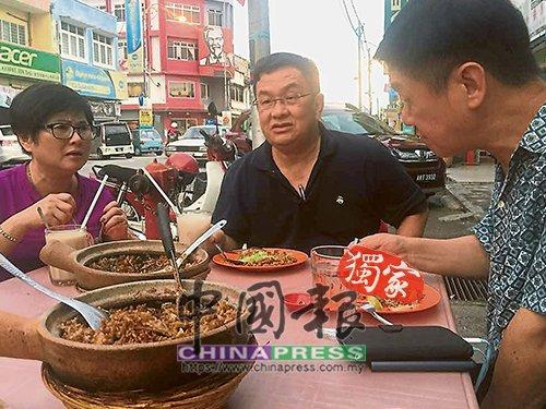 中國僑網(wǎng)李志亮(右起)與游上運(yùn),,在金寶敘舊時(shí)共同享用瓦煲雞飯。(馬來西亞《中國報(bào)》)