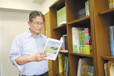 中國僑網(wǎng)藤島昭在東京理科大學(xué)辦公室里翻閱其撰寫的《科學(xué)家與中國古典名言集》一書,。記者 劉軍國攝