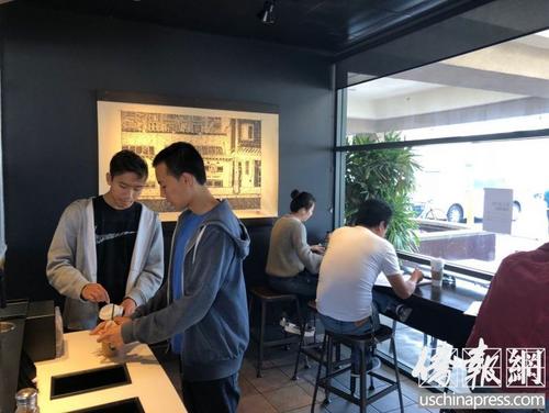 中國僑網(wǎng)兩名華裔學(xué)生正在為咖啡加糖,。美國《僑報(bào)》/高睿 攝)