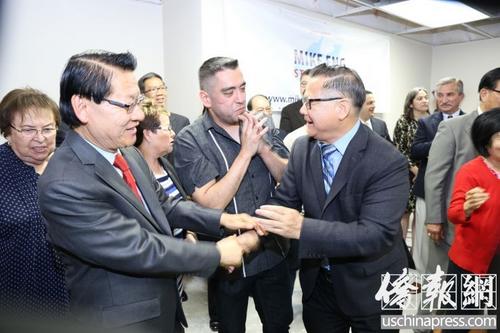中國僑網美國圣蓋博市議員廖欽和(右)向伍國慶表示祝賀,。(美國《僑報》/高睿 攝)