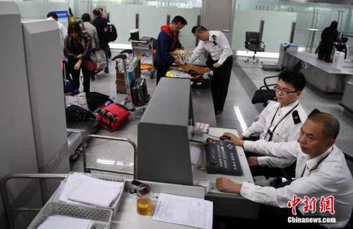 中國僑網(wǎng)資料圖:圖為福州海關(guān)隸屬長樂機(jī)場海關(guān)關(guān)員對入境旅客實施過機(jī)查驗,。 中新社記者 張斌 攝