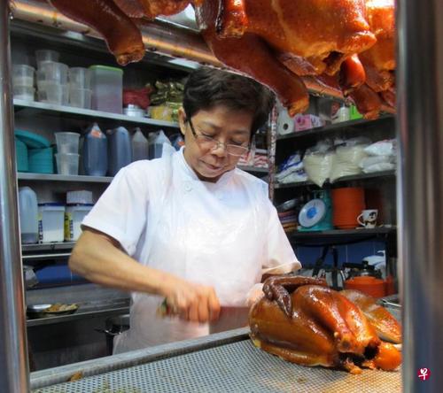 中國僑網(wǎng)蕭佩玲向父親學(xué)習(xí)如何制作油雞,,從準(zhǔn)備材料、烹煮到斬雞肉,,她凡事都親力親為,。(新加坡《聯(lián)合早報(bào)》檔案照)