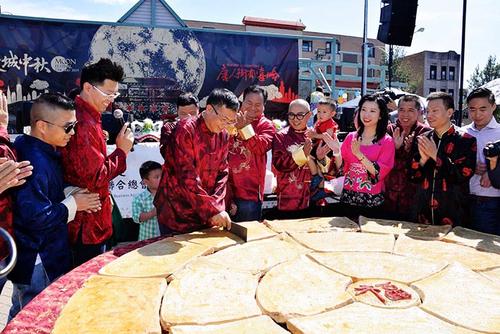 中國僑網(wǎng)“芝加哥中秋嘉年華”首次出現(xiàn)“千人大月餅”。圖為主辦單位福建商會聯(lián)合總會會長鄭時坦在開切月餅,。(《芝加哥華語論壇》/張大衛(wèi) 攝)