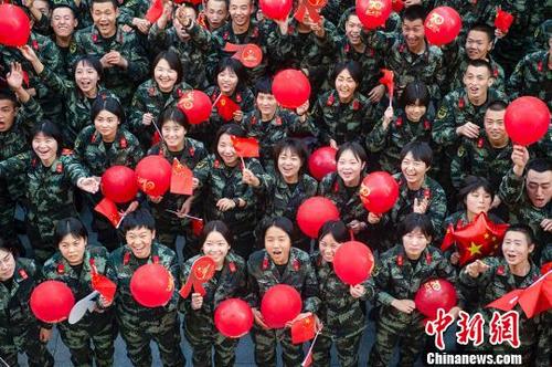 中國僑網(wǎng)武警官兵手拿氣球,、國旗,,歡呼祝福祖國?!『畛缁邸z
