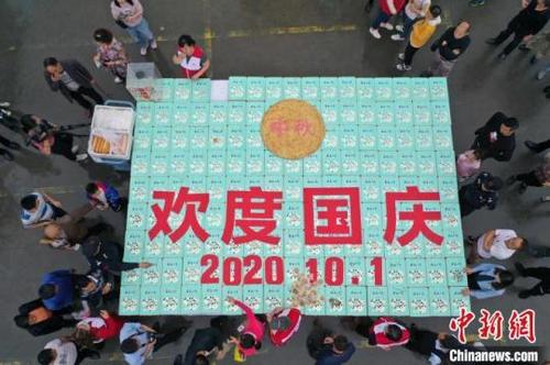 中國僑網(wǎng)工作人員用月餅擺“歡度國慶”字樣。楊孝永 攝