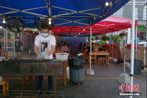 中國僑網(wǎng)當?shù)貢r間6月30日,加拿大多倫多,,一家中餐廳在室外就餐區(qū)設(shè)置燒烤服務(wù),。中新社記者 余瑞冬 攝