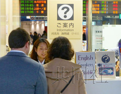 圖為11月25日站員在JR東京站丸之內(nèi)地下中央口的問詢處向外國游客進行解答,。(日本共同社)