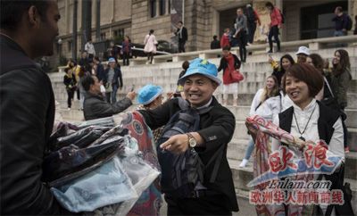 兩名游客在商販?zhǔn)种匈徺I假冒偽劣商品,。