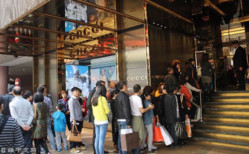 2013年春節(jié)期間,中國(guó)大陸游客在香港的奢侈品門店前排隊(duì)