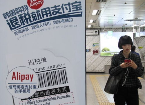 支付寶早已走出國門,,這是2014年11月5日,一名行人走過首爾地鐵里的支付寶廣告,。新華社記者姚琪琳攝