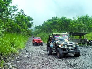 敞篷越野車行駛在前往火山山腰的路上,。