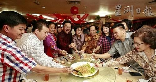 中國(guó)僑網(wǎng)黃惠康(左四)與嘉賓一起撈生。(馬來(lái)西亞《星洲日?qǐng)?bào)》)