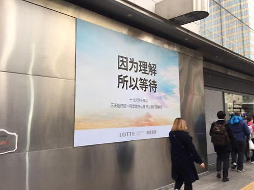 中國僑網(wǎng)在明洞樂天百貨本店外張貼有“因為理解,,所以等待”的海報