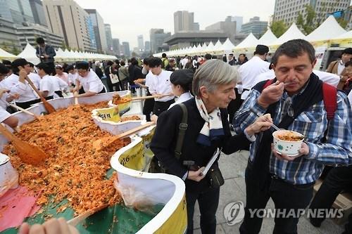 中國僑網(wǎng)資料圖片:2016年10月26日,,在首爾光化門廣場,,參加“第四屆韓餐日”活動(dòng)的外國游客品嘗拌飯,。(韓聯(lián)社)