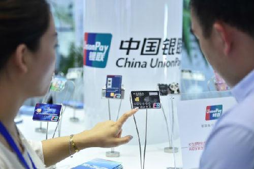中國僑網(wǎng)資料圖片:中國銀聯(lián)工作人員介紹產(chǎn)品,。(新華社)