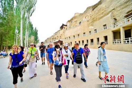 中國(guó)僑網(wǎng)圖為6月24日,國(guó)內(nèi)外旅行商考察團(tuán)在敦煌莫高窟參觀考察,?!⊥醣筱y 攝