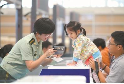 中國僑網(wǎng)圖為邊檢人員熱情為旅客服務(wù)。 謝明明 單 鈺攝