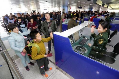 中國(guó)僑網(wǎng)資料圖:邊檢站民警為出境游返程的旅客辦理通關(guān)手續(xù),。新華社發(fā)