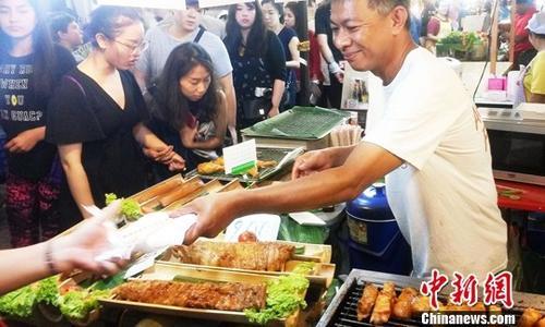中國僑網(wǎng)資料圖,,泰國美食吸引大批食客,。在泰國清邁夜市觀光具有泰北特色的小吃品種繁多,,炸豬皮、青辣椒醬,、無骨炸魚,、芒果糯米飯、烤大頭蝦,、烤鱷魚串以及榴蓮餅,、蛋黃椰絲小餅等美味食品吸引眾多游客。中新社記者 錢興強 攝