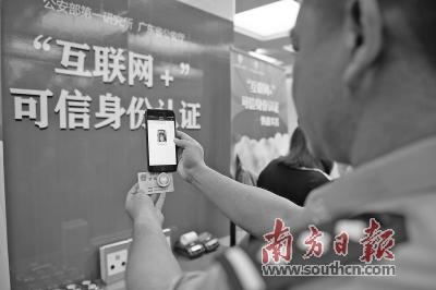 中國僑網(wǎng)民警現(xiàn)場演示“微警認證”APP業(yè)務(wù)辦理中的“刷臉”功能,。南方日報記者 張梓望 攝