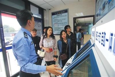 中國僑網(wǎng)通州公安分局出入境自助服務(wù)廳,,民警介紹自助簽注機的功能和使用方法,。