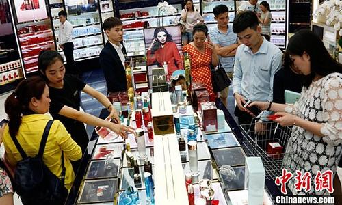 中國僑網(wǎng)資料圖:海南三亞,游客在三亞國際免稅城購買免稅商品,。中新社記者 尹海明 攝