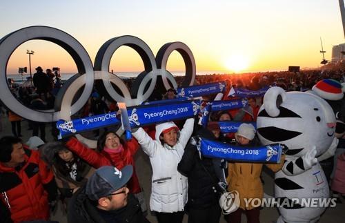 中國僑網(wǎng)資料圖片:2018年1月1日,在江陵鏡浦海邊,平昌冬奧會志愿者們在宣傳冬奧,。(圖片來源:韓聯(lián)社)