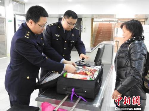 中國(guó)僑網(wǎng)檢驗(yàn)檢疫人員在查驗(yàn)旅客出境行李 高明出入境檢驗(yàn)檢疫局供圖 攝