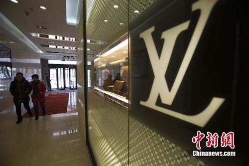 中國僑網(wǎng)資料圖:民眾從某知名奢侈品店經(jīng)過,。中新社記者 張云 攝