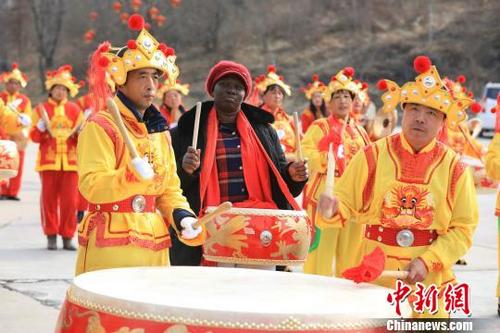 中國僑網(wǎng)1月28日,來自“一帶一路”沿線幾個(gè)國家的留學(xué)生組團(tuán)來到山西王莽嶺太行云頂體驗(yàn)中國年,。圖為外國留學(xué)生與村民們一起敲鑼打鼓,。 張為濤 攝