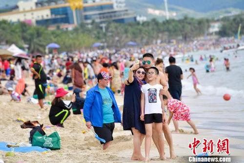 中國僑網(wǎng)圖為在三亞海濱浴場旅游的游客,?!●樤骑w 攝