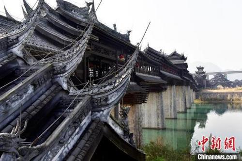 中國僑網(wǎng)圖為濯水古鎮(zhèn)內(nèi)一座橫跨阿蓬江的純木結(jié)構(gòu) “風雨廊橋”?!×_永皓 攝