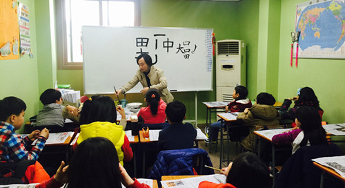 中國僑網(wǎng)李亭老師在教授中國書法課,。
