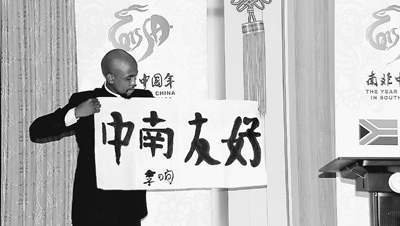 中國僑網(wǎng)南非德班理工大學(xué)選手李響向觀眾展示他的書法作品。(蔣安全 攝)