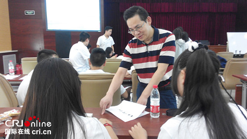 北京華文學院的漢語培訓教師廖崇陽輔導營員學習漢語,。(李紅