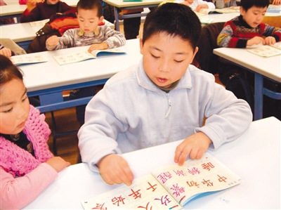 圖為丹華學(xué)生正在認(rèn)讀《中華字經(jīng)》上的漢字