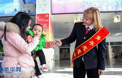 1月27日,,瑪麗婭(右一)在琿春站與一名帶著寶寶的旅客交流。新華社記者