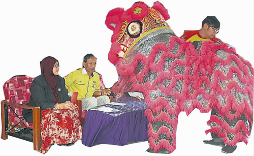 校長娜哈瑪與家協(xié)主席沙立夫與醒獅互動(dòng)并遞上年柑,。