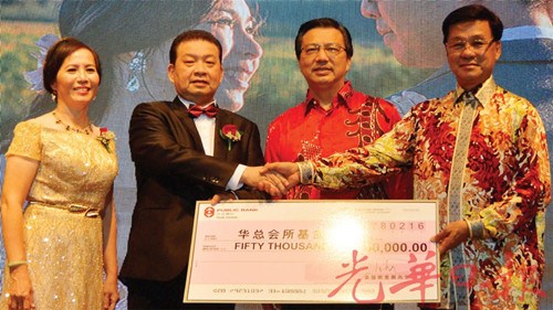 方天興(右)在廖中萊(右2)見證下,,從蔡兆生與林淑英夫婦手中接過(guò)捐獻(xiàn)華總大廈基金模擬支票。